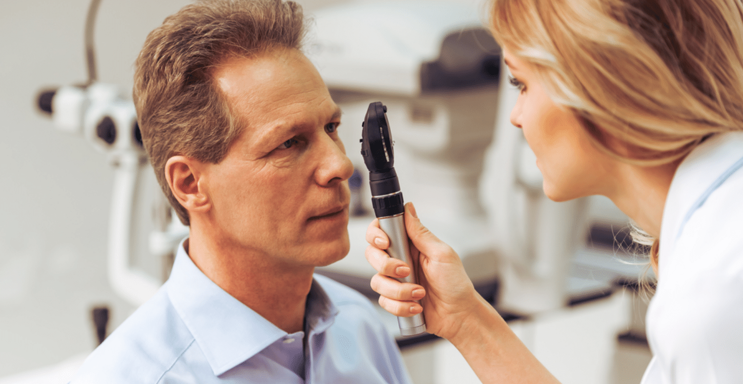 Um homem fazendo exame oftalmológico (Fundoscopia)